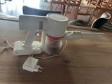 un mixeur blanc et rouge posé sur une table en bois