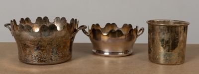 trois vases en argent posés les uns à côté des autres sur une table
