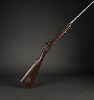 an old rifle with a wooden barrel and a metal handle