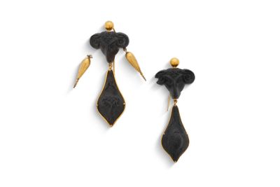Les boucles d'oreilles noires et dorées sont disposées sur un fond blanc