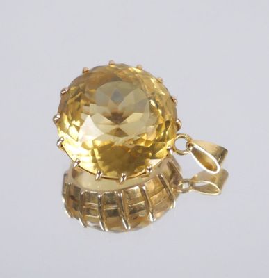 a close up of a yellow topaz stone pendant on a white background