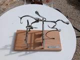 a metal sculpture on a wooden stand on a table