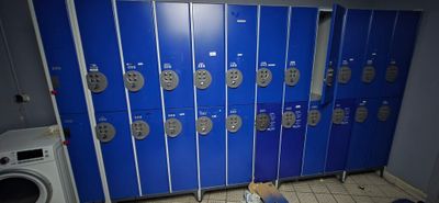 many blue lockers in a room with a washer and dryer