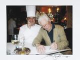 deux chefs assis à une table, en train d'écrire sur une feuille de papier