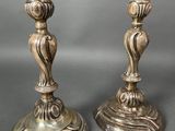pair of antique brass candlesticks on pedestal on grey background