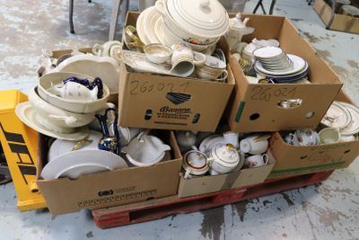 de nombreuses caisses de vaisselle blanche et de bols posées sur une palette