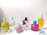 several bottles of perfume are lined up on a white surface