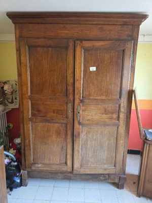 a large wooden armoire in the corner of a room