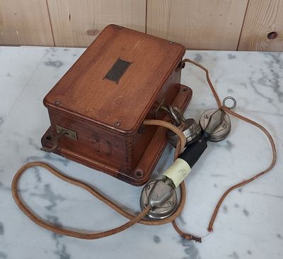 une boîte en bois à laquelle est attachée une cordelette, posée sur une surface en marbre
