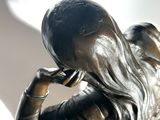 a statue of a woman holding a cell phone to her ear