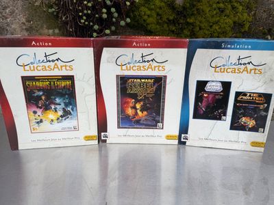 trois DVD sont posés sur une table devant un mur de pierre