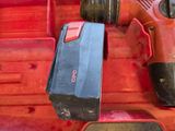 a drill in a tool box with a hammer in it