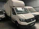 three white vans are parked in a garage with other vans in the background