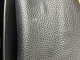 the back of a black leather purse sitting on top of a table