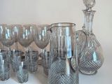 many glasses and a decanter sitting on a table