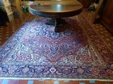 a large rug on the floor with a table in the middle