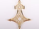 gros plan d'un pendentif en or sur fond blanc