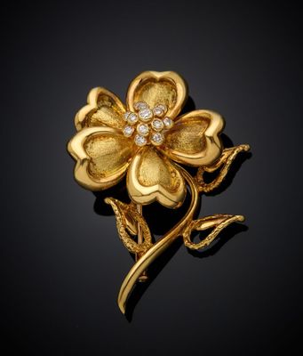 un gros plan d'une broche en forme de fleur dorée sur fond noir