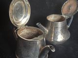 deux tasses en argent et une théière en argent sur fond noir