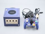 une console de jeux vidéo et une manette de jeu placées l'une à côté de l'autre