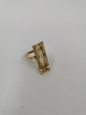 Gros plan sur une bague en or ornée d'une pierre verte