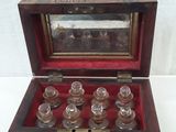 a small wooden box with six glass bottles inside of it