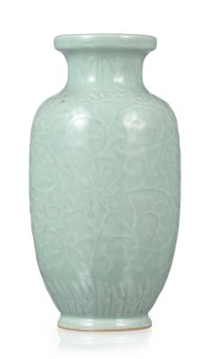 un vase vert posé sur une surface blanche