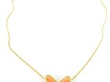 un collier représentant un papillon orange avec une chaîne dorée sur fond blanc