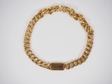a gold chain bracelet with a nameplate on it
