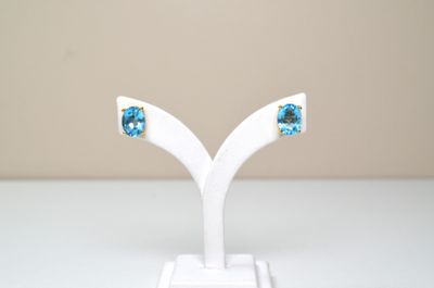 une paire de boucles d'oreilles posée sur un présentoir blanc