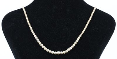 un collier de perles blanches autour du cou d'un mannequin