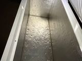 a white cooler sitting in the dark on the floor