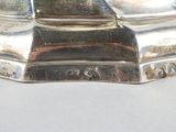 an image of a silver plate on a table with a clock on top of it