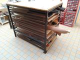 un homme assis sur une table, avec un présentoir à chaussures à côté de lui