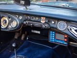 a dashboard of a car with a clock and a steering wheel