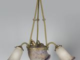 un lustre ancien en laiton, muni de trois abat-jours en verre, suspendu au plafond