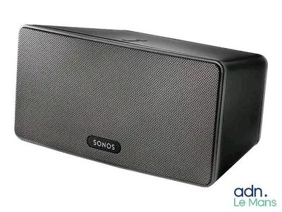 une enceinte noire posée sur une surface blanche