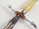 a close up of a knife on a white surface