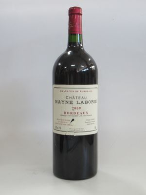 the bottle of red wine is sitting on a white surface