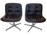 paire de fauteuils pivotants en cuir noir avec des pieds chromés