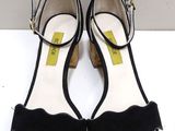 a pair of black heels with a bow on the heel