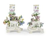 deux vases blancs ornés de fleurs, posés sur une table