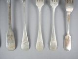five forks and two spoons on the table