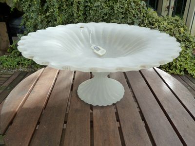 a white flower shaped cake plate on a wooden table
