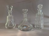 three glass decantes sitting on a table