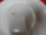 a close up view of a white bowl on a red table