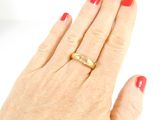a woman ' s hand with a gold ring on it