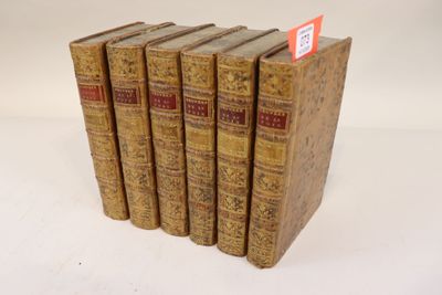 six vieux livres empilés les uns sur les autres sur une surface blanche