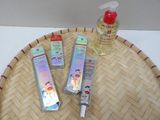 three bottles of lotion sitting on top of a bamboo tray