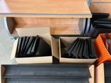 many boxes of black plastic items on the floor